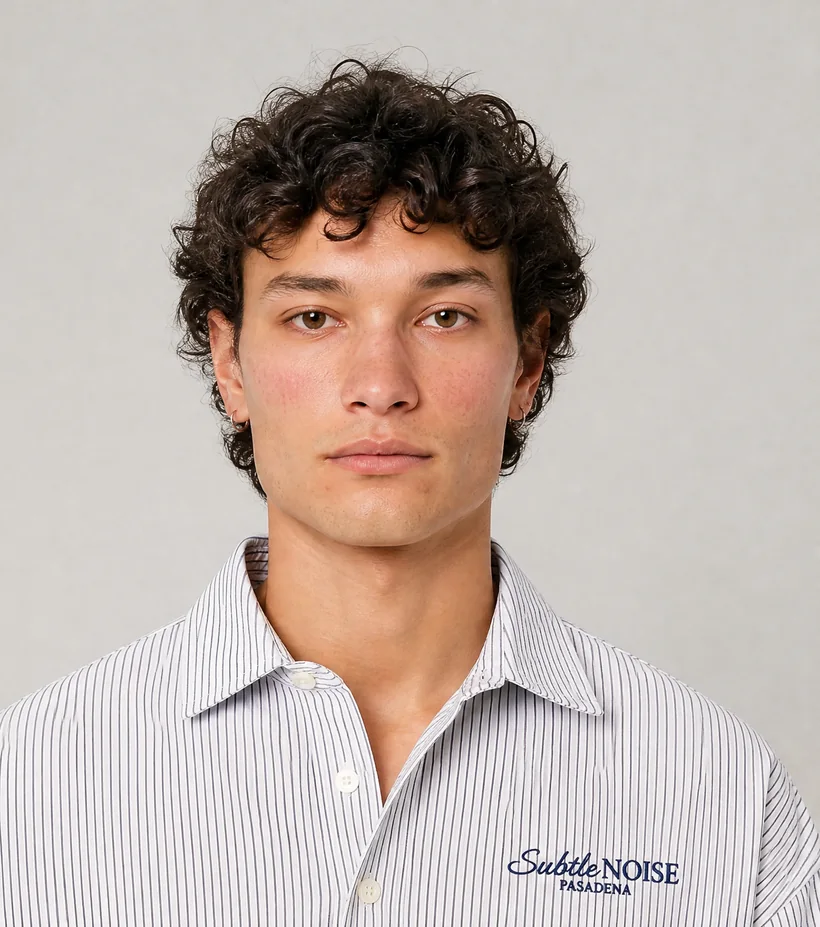 Retrato de modelo con camisa de rayas finas sobre fondo neutro